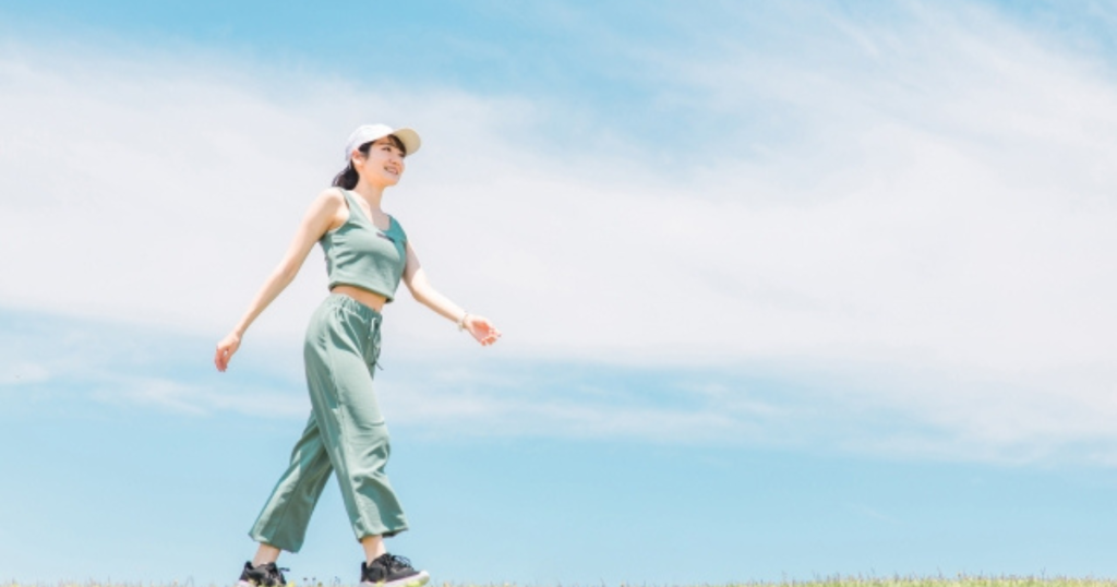 女性が青空の下で歩いている