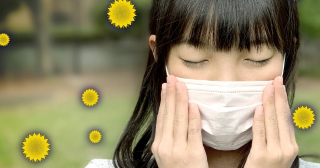 女性が花粉症によりマスクをさえている画像